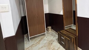 A room with a marble floor, a wooden wardrobe, a mirror cabinet, and a white ceiling. - S R HOTEL (Varanasi)