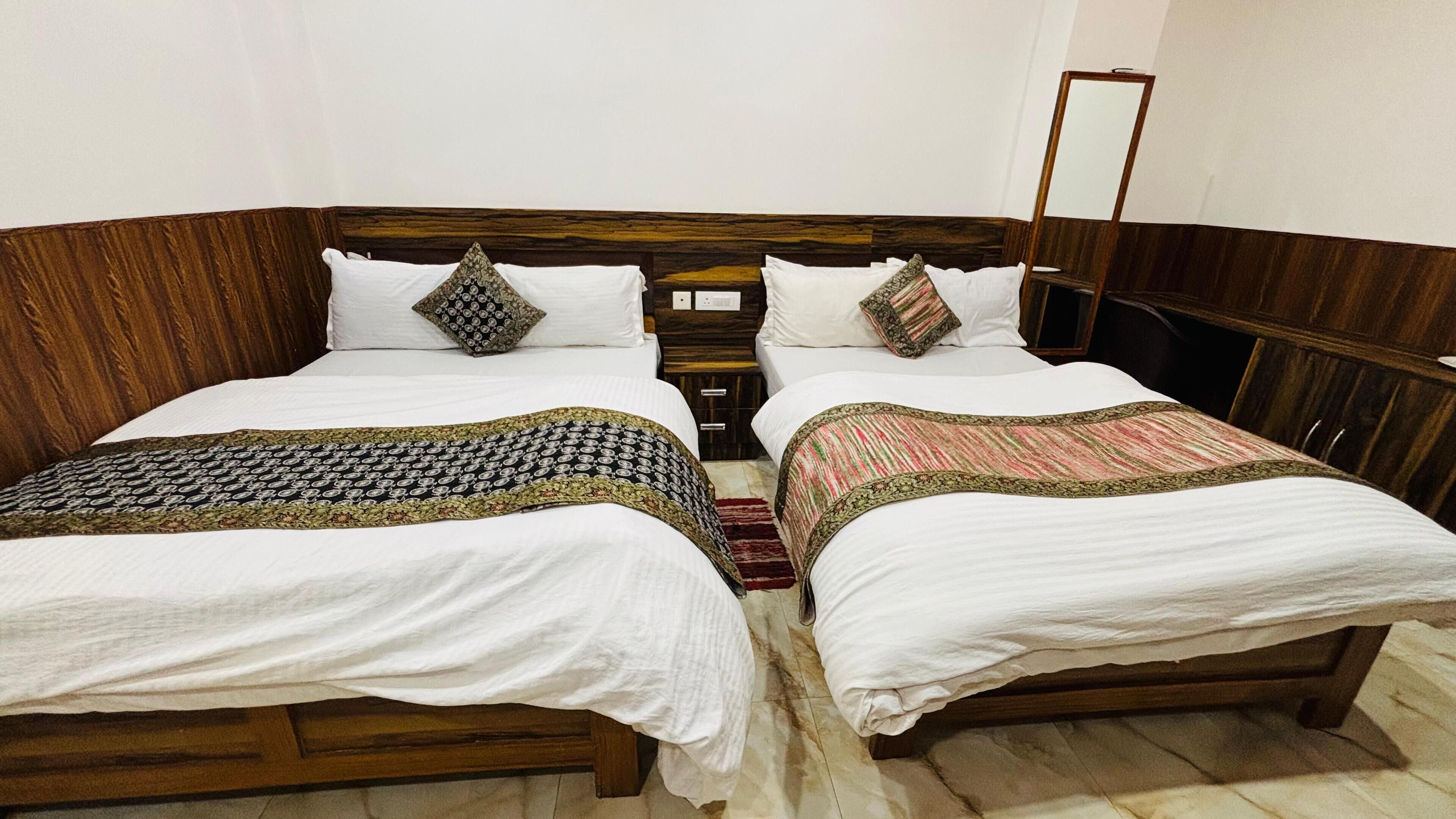 A double bed room with a wooden headboard, two bedside tables, and a mirror on the wall.