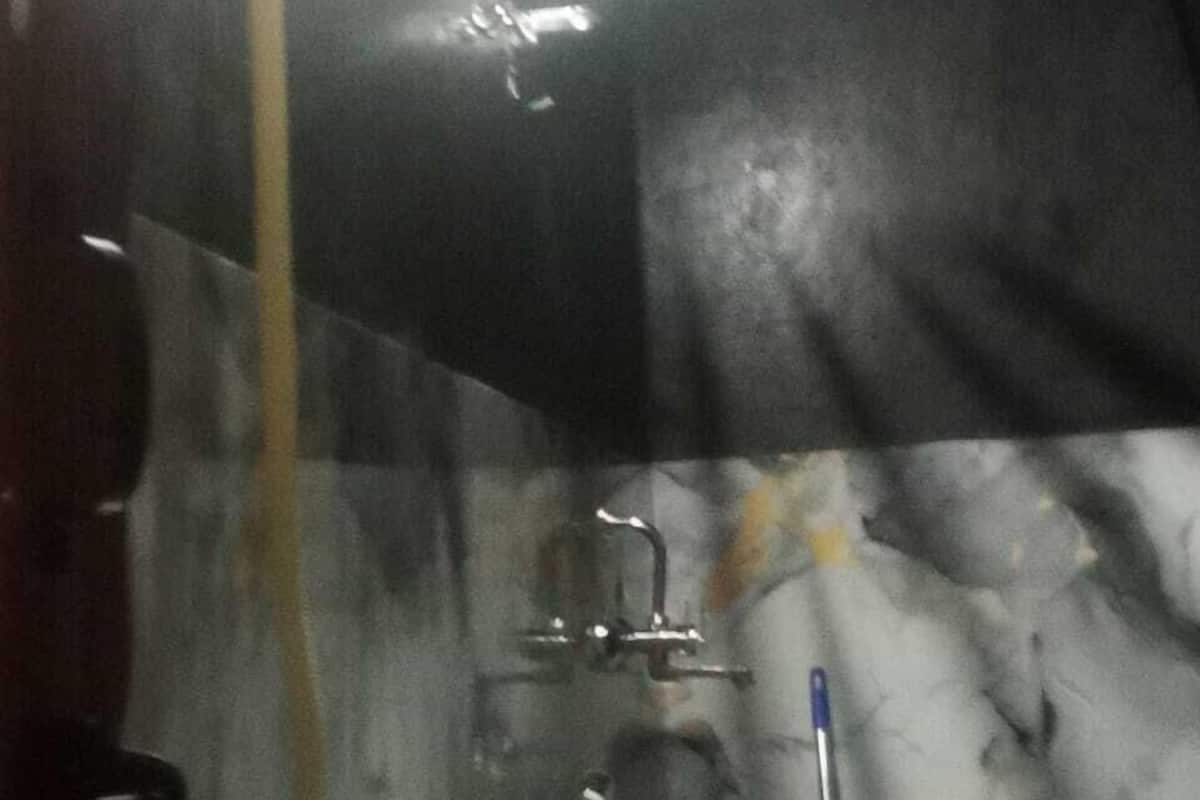 Ein Badezimmer mit Marmorwand, Toilette in Weiß und einer Duschkabine.