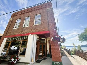 A two-story brick building with a red awning and a storefront labeled "COUNTRY MEATS." - Historic Lakeview Apartment Above Iconic One (Harrison)