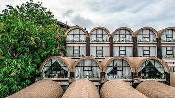 A building with multiple arched windows and balconies with plants.