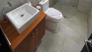 Un baño moderno con lavamanos, inodoro y ducha blancos.