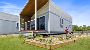 A modern single-story house with a sloped roof, large windows, and a wooden deck. - Ingenia Holidays Kinka Beach Yeppoon (Kinka Beach)