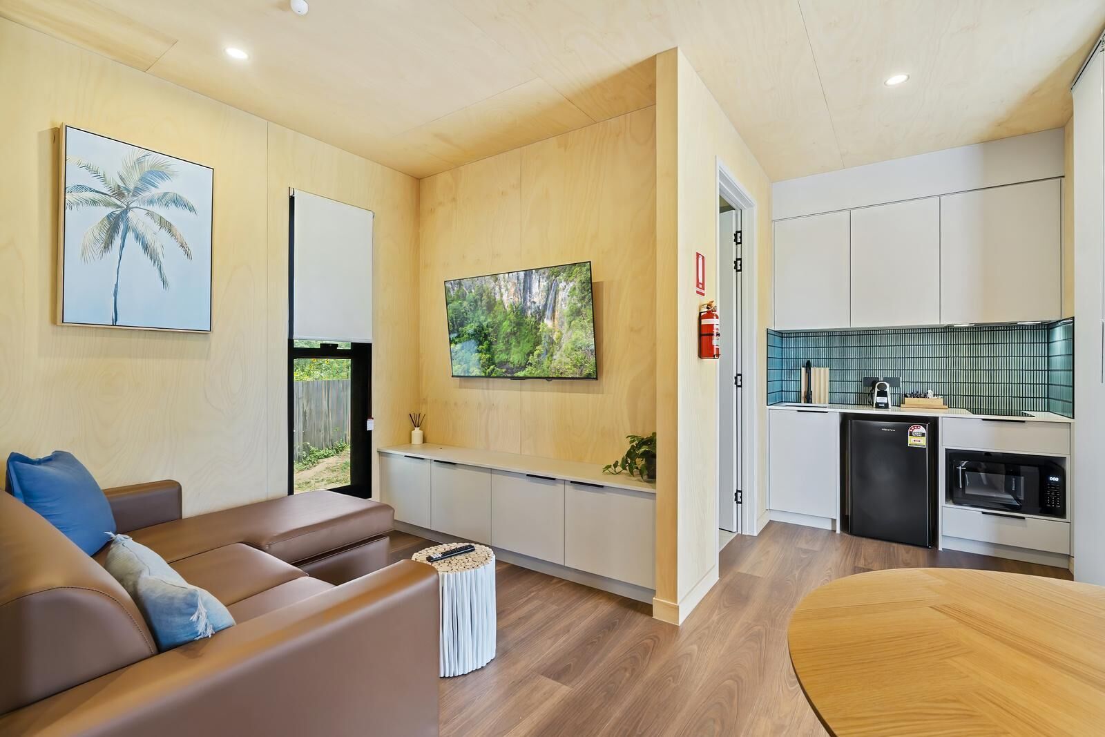 Una sala de estar moderna con un sofá, una mesa de centro y un televisor montado en la pared.