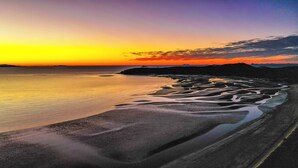 A beach with a calm sea, a clear sky, and distant mountains. - Ingenia Holidays Kinka Beach Yeppoon (Kinka Beach)