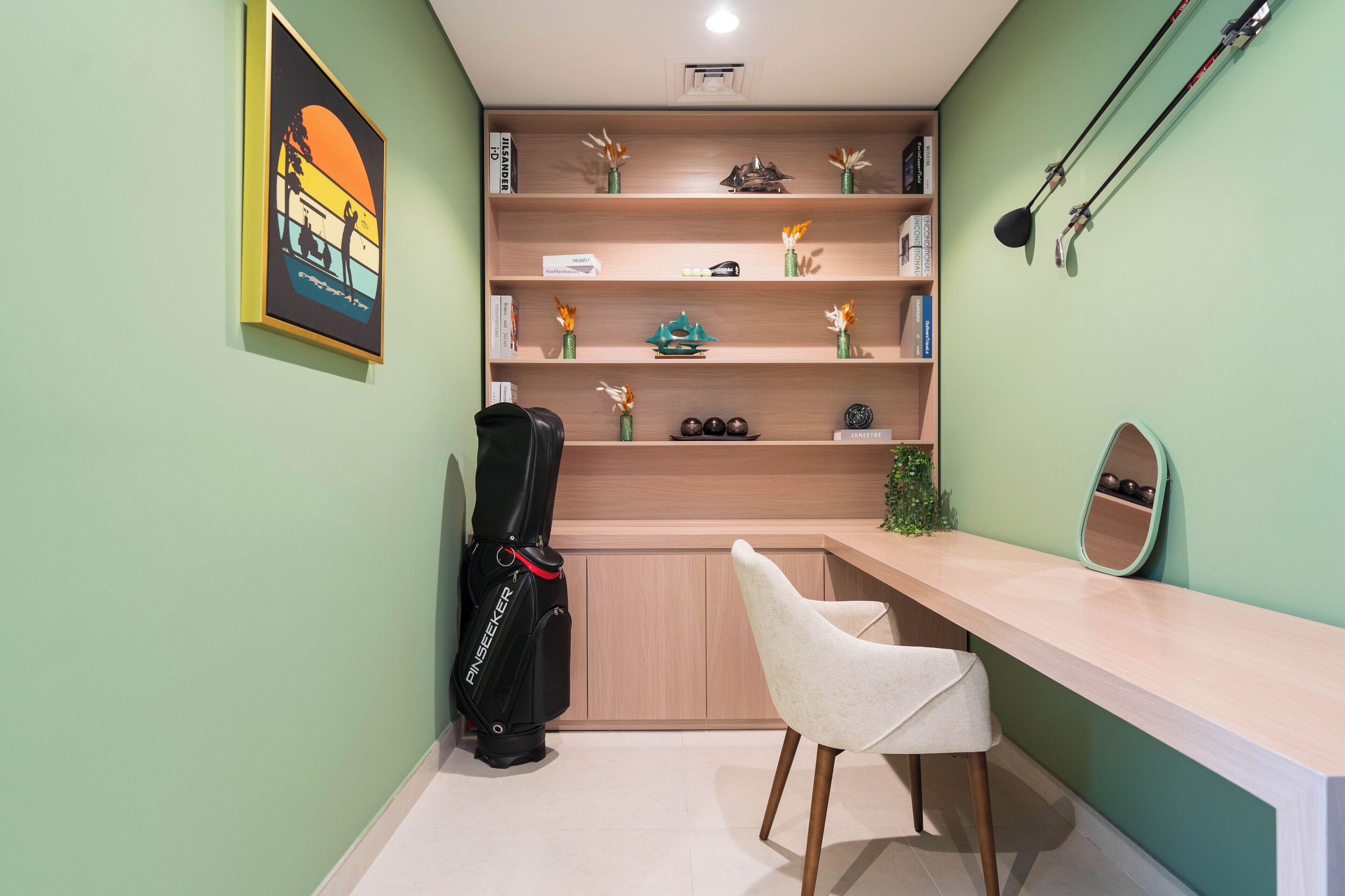A room with a desk, chair, shelves with decorative items, a guitar, and a framed picture on the wall.