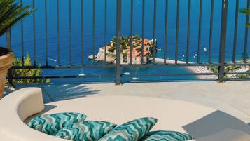 A balcony with a view of the sea and a distant island.