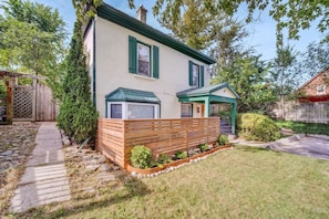 A two-story house with a wooden fence, a small garden, and a pathway leading to the front door. - Stylish Urban Escape - Close to DTK and Expwy (Kitchener)