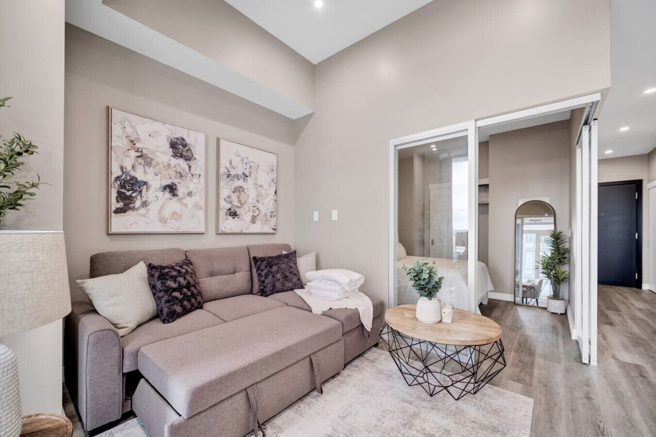 A modern living room with a sofa, coffee table, and artwork on the wall.
