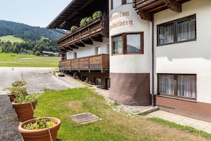A building with a balcony, a sign reading 'Pension Gödelsberg,' and a view of a green landscape.