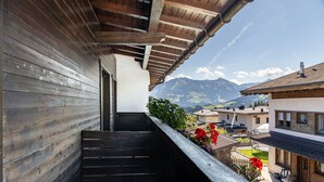 A wooden balcony with a view of mountains and a garden. - Room '09' with Mountain View, Shared Terrace and Wi-Fi (Hopfgarten im Brixental)