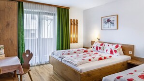 A bedroom with a wooden bed, a desk, and a chair. - Room '09' with Mountain View, Shared Terrace and Wi-Fi (Hopfgarten im Brixental)