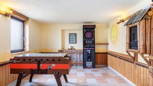 A room with a foosball table, a dartboard, and a dart machine. - Room '09' with Mountain View, Shared Terrace and Wi-Fi (Hopfgarten im Brixental)