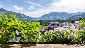 A residential area with houses, green hills, and a clear sky.