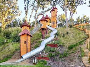 A playground with wooden structures and a slide.