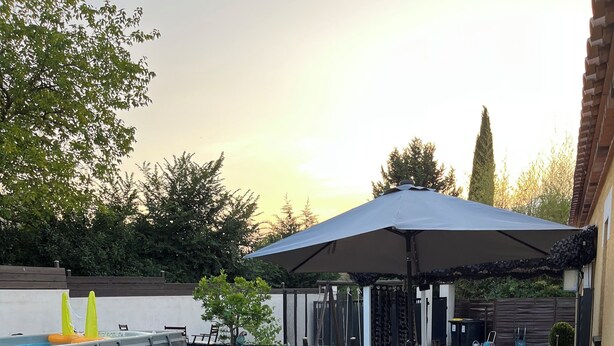 Ein Außenbereich mit Terrasse, Whirlpool, Holzmöbeln und einer überdachten Lounge-Ecke.