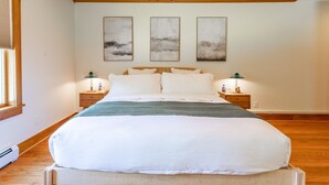A large bed with white linens, two bedside tables with lamps, and three abstract paintings on the wall. - NEW: Multi-Generational Haven nr Roscoe (Roscoe)