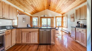 A spacious kitchen with wooden cabinets, a central island, and a large window providing natural light. - NEW: Multi-Generational Haven nr Roscoe (Roscoe)