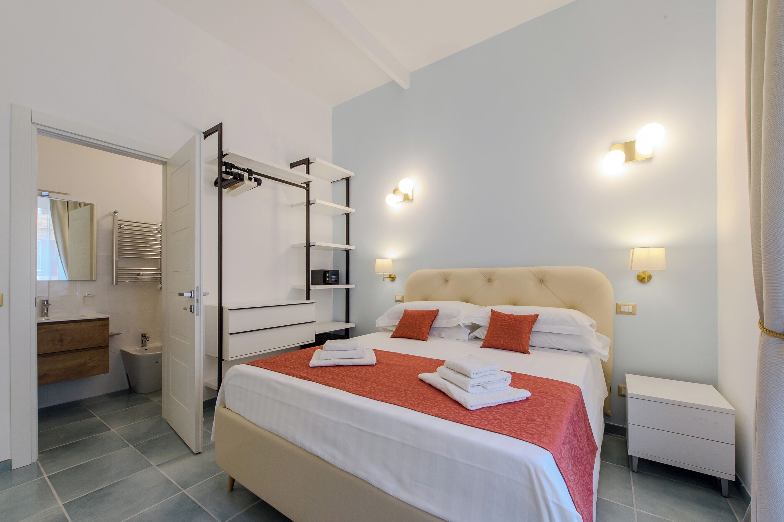 Una habitación de hotel con cama, mesitas de noche, armario y baño.