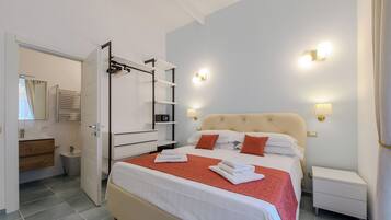 Una habitación de hotel con cama, mesitas de noche, armario y baño.