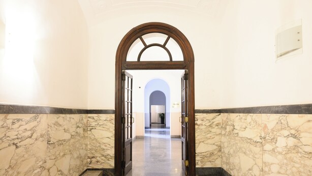 A marble-floored hallway with a wooden archway leading to a room labeled "Unseen." - Magnoliahome Suites at the Vatican (Rome)