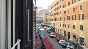 A street view with parked cars, buildings, and a visible sign for a parking garage. - Magnoliahome Suites at the Vatican (Rome)