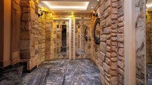 A hallway with stone walls, a marble floor, and a staircase leading to a door marked 203. - REN PLUS SUİTES OTEL (İstanbul)