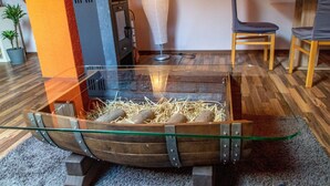 A glass-top table with a wooden boat-shaped base, straw bedding, and a small heater. - Apartment 'Moselglück' with Mountain View, Wi-Fi and Air Conditioning (Sankt Aldegund)