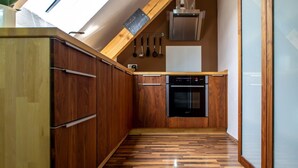 A kitchen with wooden cabinets, a built-in oven, and a skylight. - Apartment 'Moselglück' with Mountain View, Wi-Fi and Air Conditioning (Sankt Aldegund)