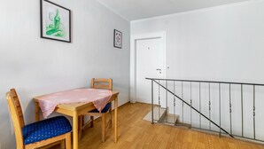 A room with a wooden table, a chair, a staircase with a metal railing, and a door marked with the number 1. - Guest Room Bruno Room 1 with Wi-Fi (Bremm)