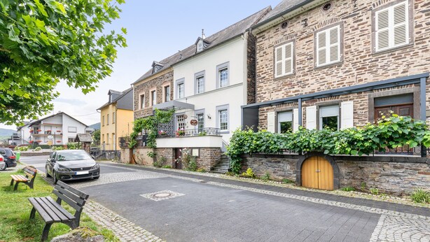 A cobblestone street with stone buildings, a parked car, and a bench. - Guest Room Bruno Room 1 with Wi-Fi (Bremm)