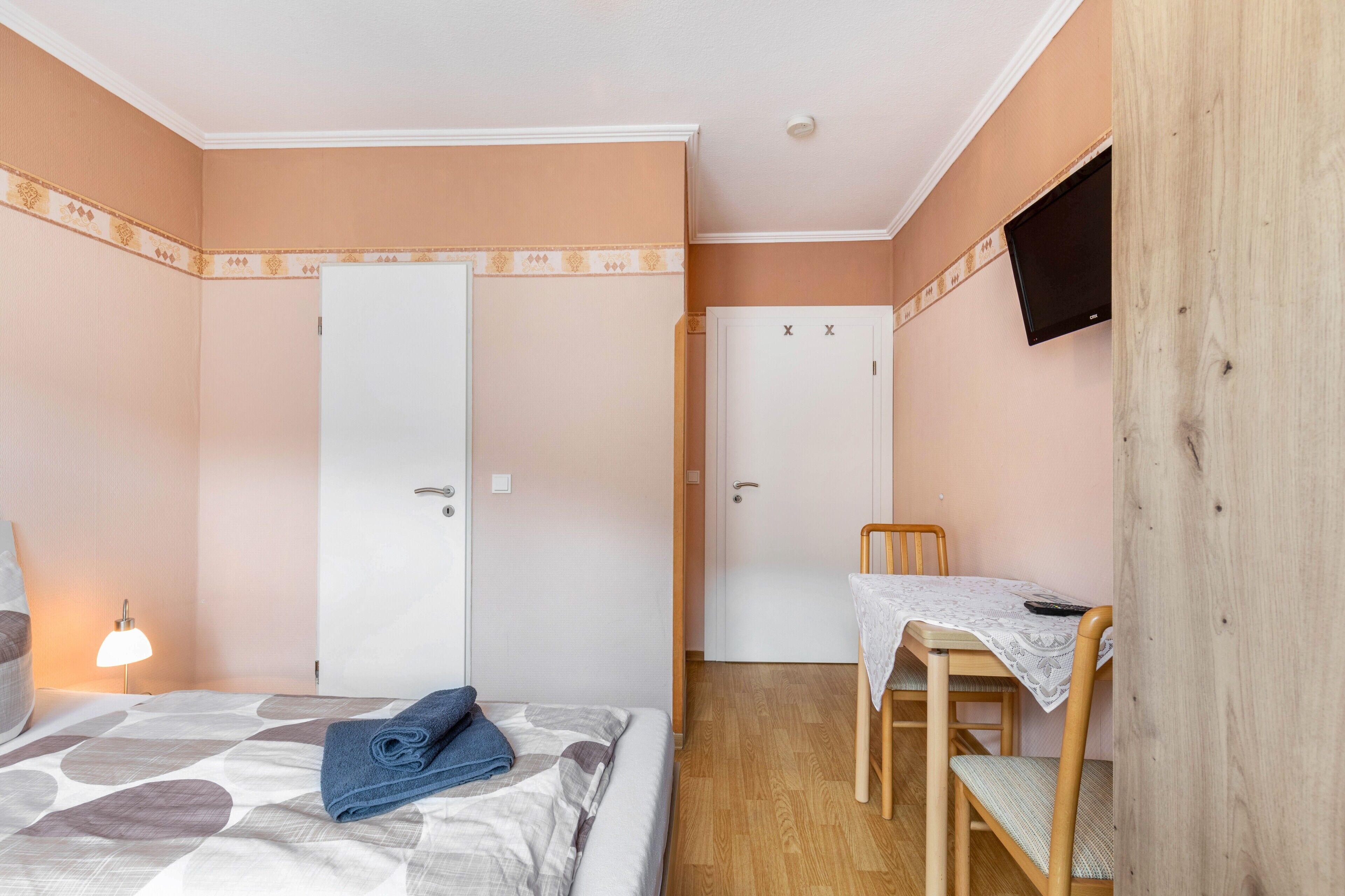 Ein Schlafzimmer mit Bett, Schreibtisch, Stuhl und Fernseher.