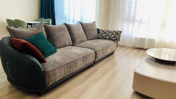 A modern living room with a sofa, a coffee table, and a dining area with chairs. -  205 In the central of Ulaanbaatar, Selbe Comfort Apartment (Ulaanbaatar)