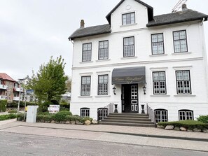 Un edificio blanco con toldo negro que dice "Haus Friesland".