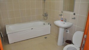 A bathroom with a bathtub, sink, and toilet.