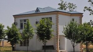 A single-story building with a flat roof, rectangular windows, and a small porch area.