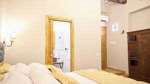 Une chambre à coucher avec un lit, une armoire en bois et une porte donnant sur une salle de bain.