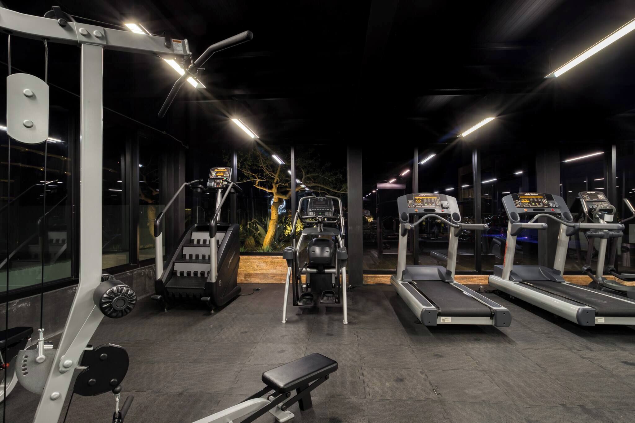 Une salle de sport équipée de divers appareils d’exercice, notamment des tapis de course et des appareils de musculation.