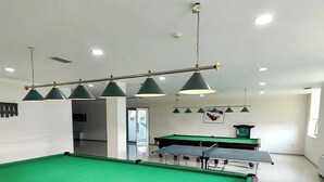 A pool table with a green felt surface, surrounded by a white wall and a ceiling with recessed lighting. - Arena Hotel Shirvan (Shirvan)