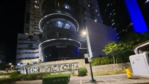 A building with a sign that reads 'Minotti' and 'FOR VICTORIA' at night.