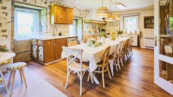 A kitchen with wooden cabinets, a dining table with chairs, and a window with a view.