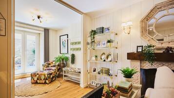 Una sala de estar con un sofá, una mesa de centro, una chimenea y una estantería.