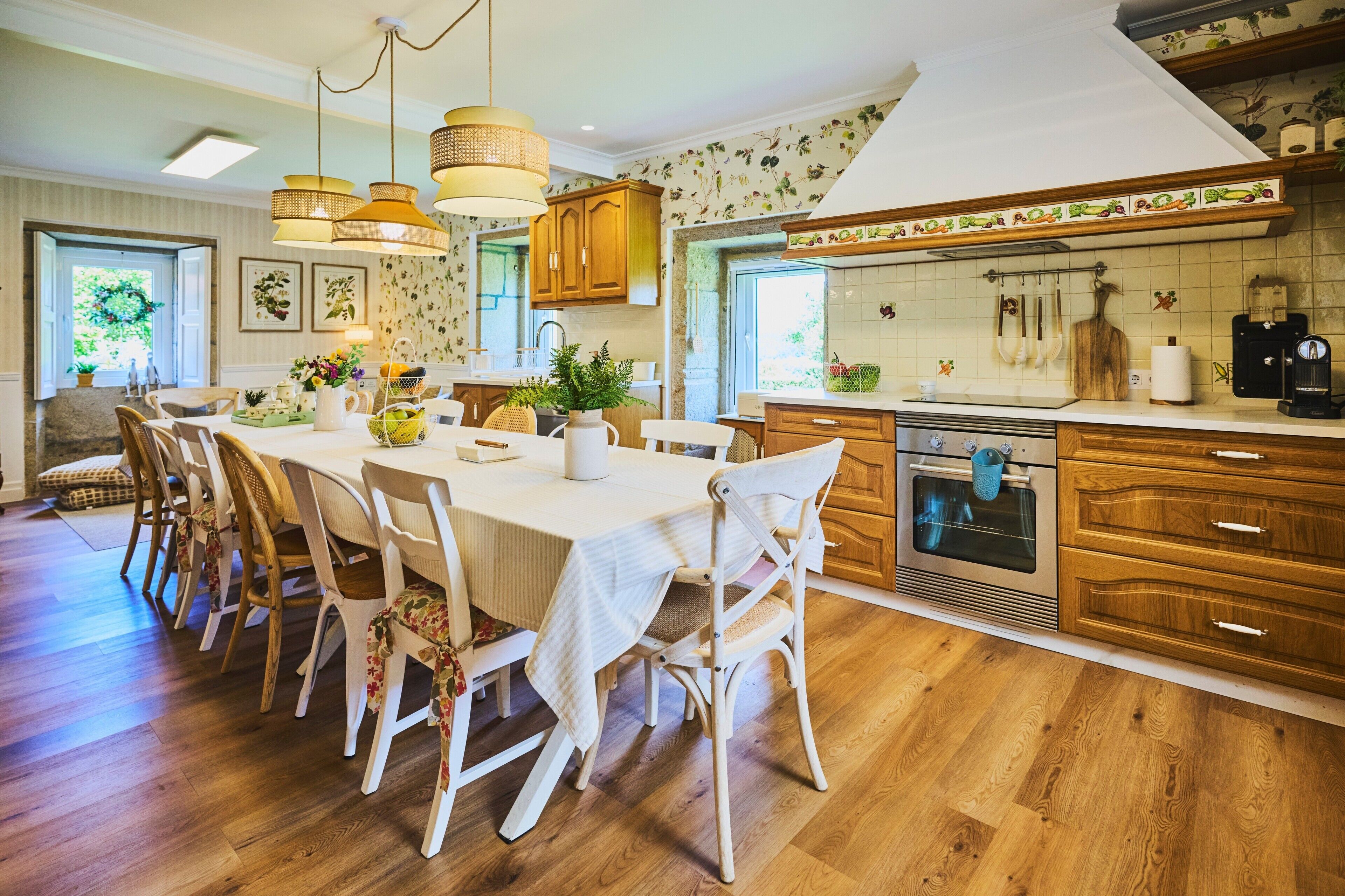 A kitchen with wooden cabinets, a dining table with chairs, and a coffee machine.