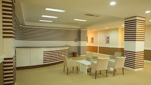 A reception area with a curved counter, multiple seating options, and a modern design with striped patterns on the walls and columns.
