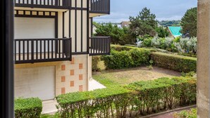 A multi-story building with balconies, a garden with hedges, and a view of surrounding houses. - Les Terrasses de Tourgeville by Interhome (Deauville-Trouville)