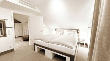 Un dormitorio con cama, armario y puerta que da a otra habitación.