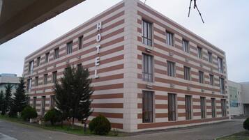 A hotel with a striped facade, multiple windows, and a flat roof.