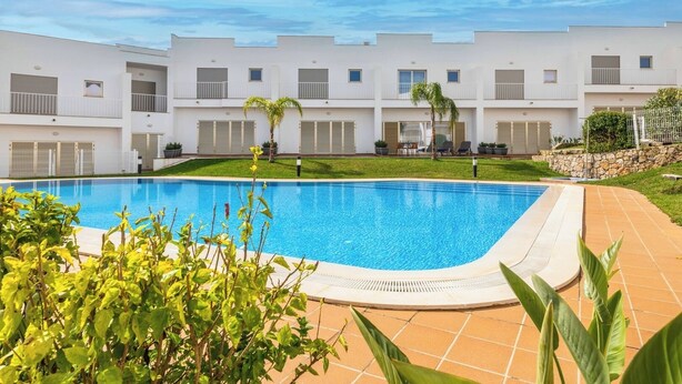 A swimming pool surrounded by a white building with balconies and a garden area. - DK Stays Residences Albufeira M13 (Albufeira)