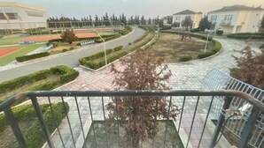 A view from a balcony overlooking a sports field, a curved road, and residential buildings. - Arena Hotel Kurdamir (Kurdamir)