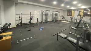 A gym with various exercise equipment, including weight machines, benches, and a squat rack. - Arena Hotel Kurdamir (Kurdamir)